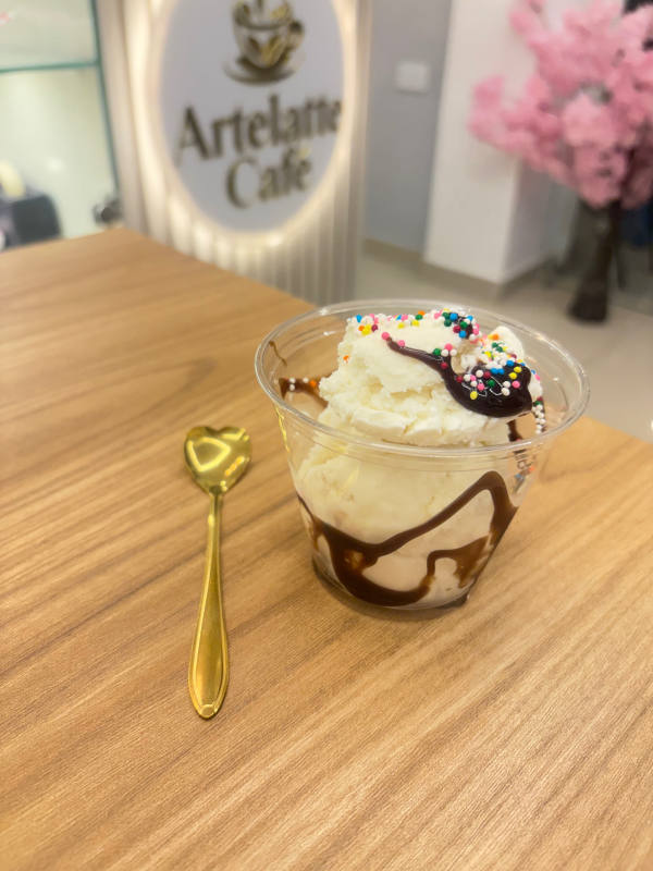 Vaso de helado con chocolate y pepitas de colores